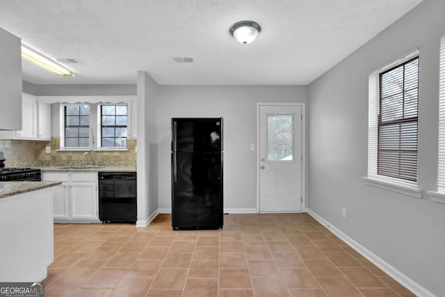 kitchen featuring backsplash, sink, black appliances, light tile patterned floors, and white cabinetry