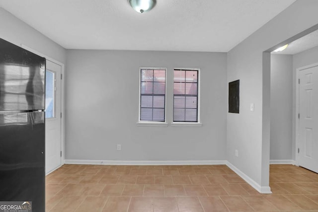 unfurnished room featuring electric panel and a textured ceiling