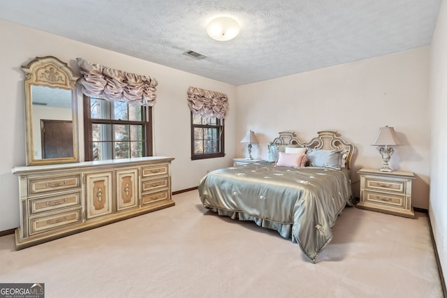 bedroom featuring light carpet and a textured ceiling