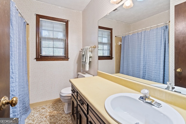 bathroom featuring vanity, toilet, and walk in shower