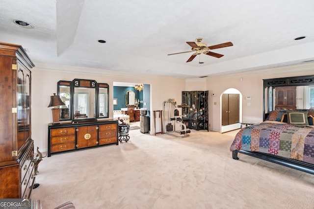 bedroom with ornamental molding, a tray ceiling, and light carpet