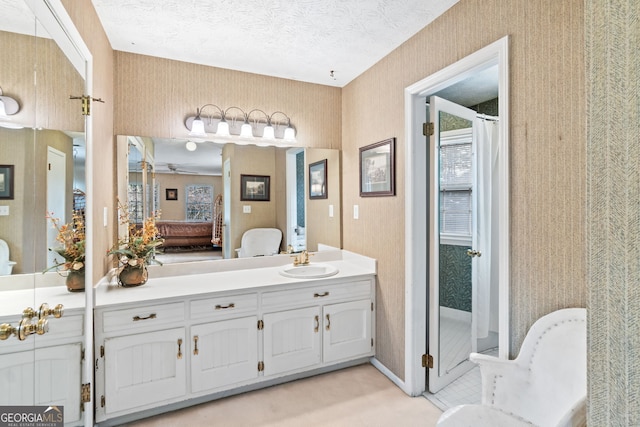 bathroom featuring walk in shower, vanity, and a textured ceiling