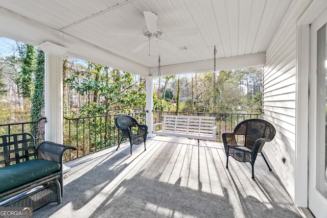 unfurnished sunroom featuring wooden ceiling and ceiling fan