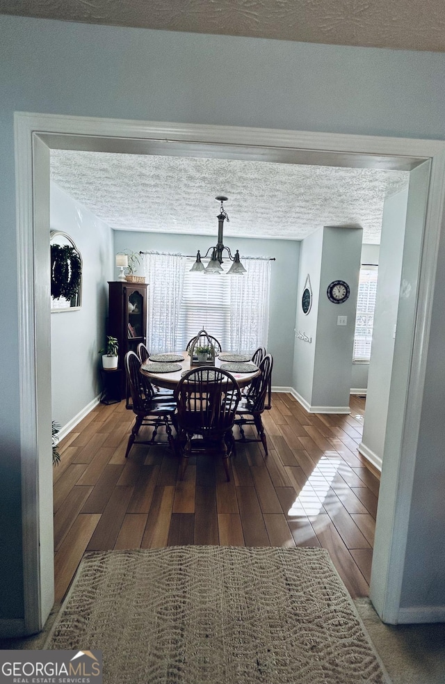 dining area featuring a chandelier and a textured ceiling