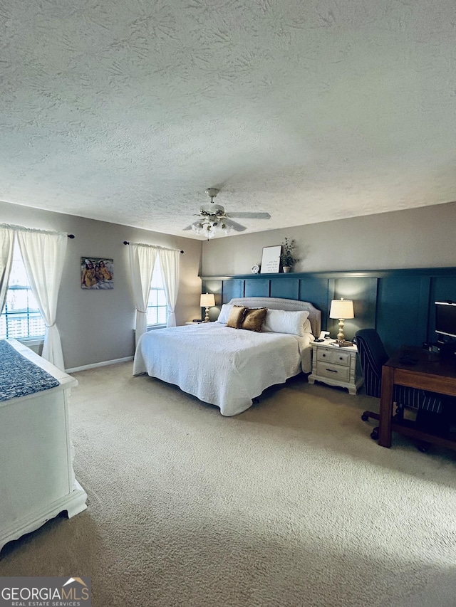 carpeted bedroom with ceiling fan and a textured ceiling