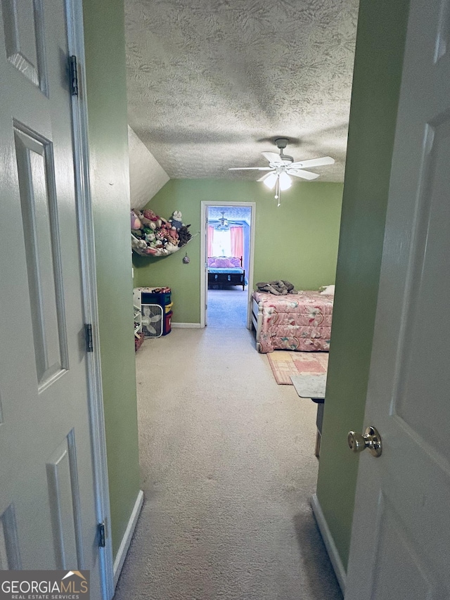 bedroom featuring carpet flooring, a textured ceiling, ceiling fan, and lofted ceiling