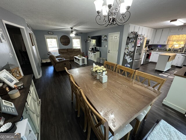 dining area featuring dark hardwood / wood-style flooring, ceiling fan with notable chandelier, a textured ceiling, and sink