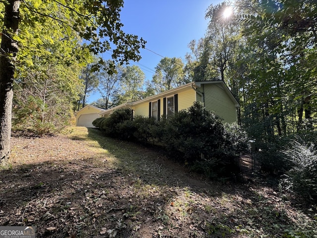 view of home's exterior with a garage and an outbuilding