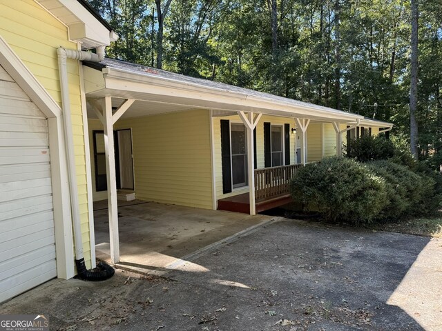 view of property exterior featuring a carport and a porch