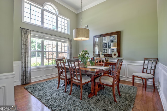 dining room with hardwood / wood-style floors and crown molding