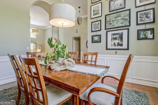 dining space with hardwood / wood-style flooring and crown molding