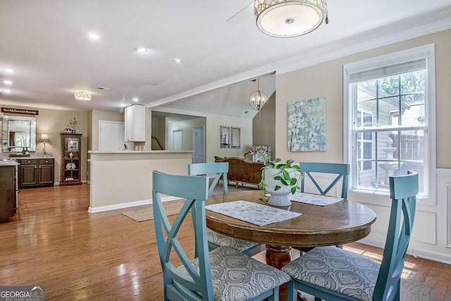 dining room with an inviting chandelier, ornamental molding, and light hardwood / wood-style flooring