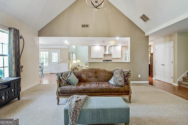 carpeted living room with high vaulted ceiling