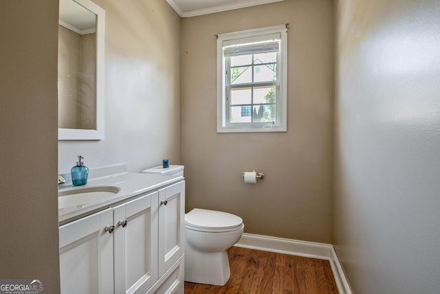 bathroom with wood-type flooring, vanity, toilet, and crown molding