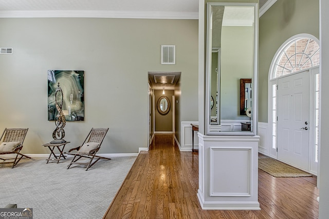 foyer entrance with wood-type flooring and ornamental molding