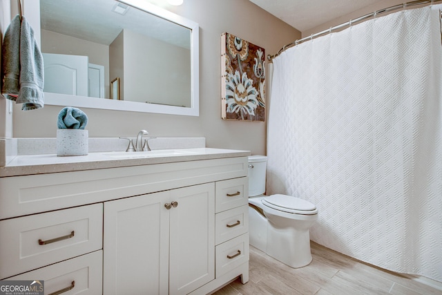 bathroom featuring hardwood / wood-style floors, vanity, and toilet