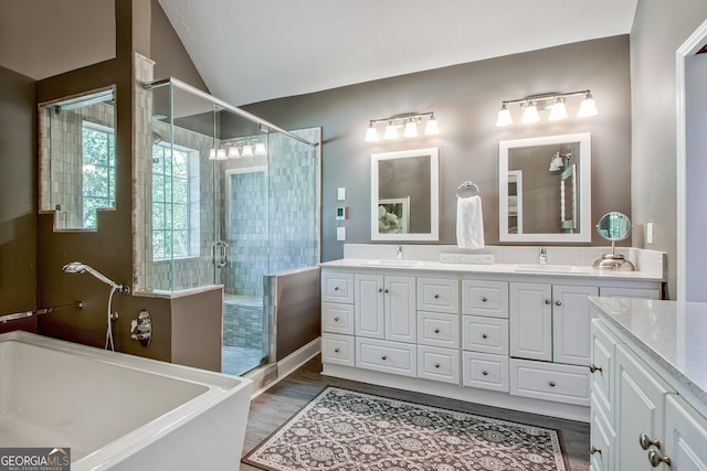 bathroom featuring vanity, wood-type flooring, lofted ceiling, and shower with separate bathtub