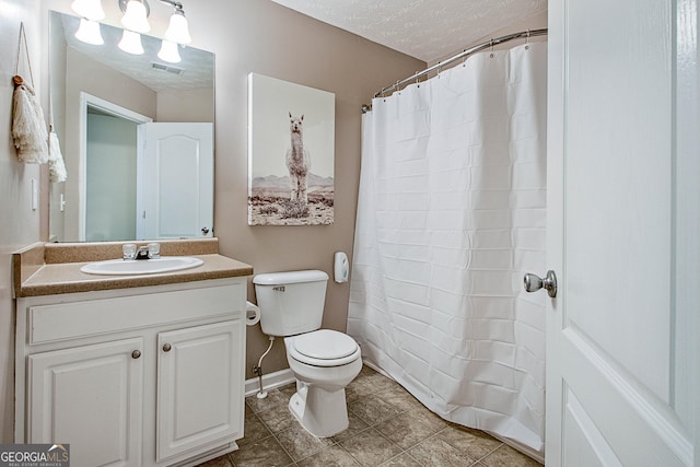 bathroom featuring a textured ceiling, vanity, and toilet