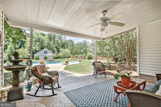 view of patio / terrace featuring ceiling fan and an outbuilding