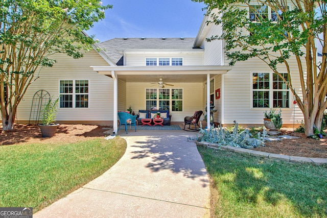 view of front of house with outdoor lounge area, ceiling fan, and a front yard