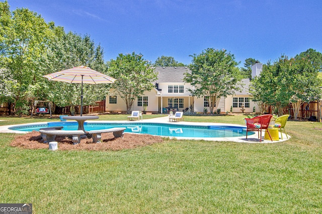 view of pool with a lawn