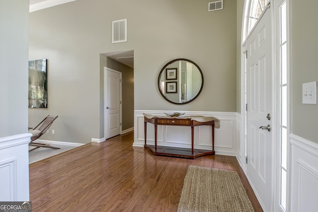 foyer with hardwood / wood-style flooring and ornamental molding