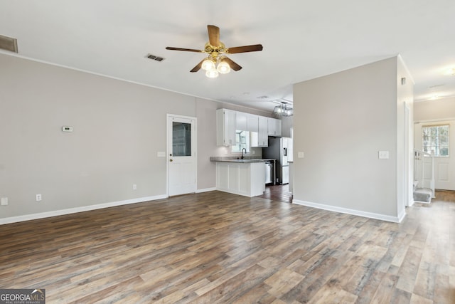 unfurnished living room featuring ceiling fan, wood-type flooring, and sink