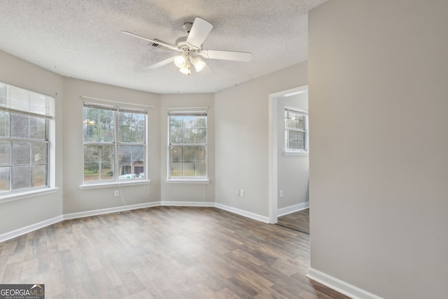 spare room with ceiling fan, dark hardwood / wood-style floors, and a textured ceiling