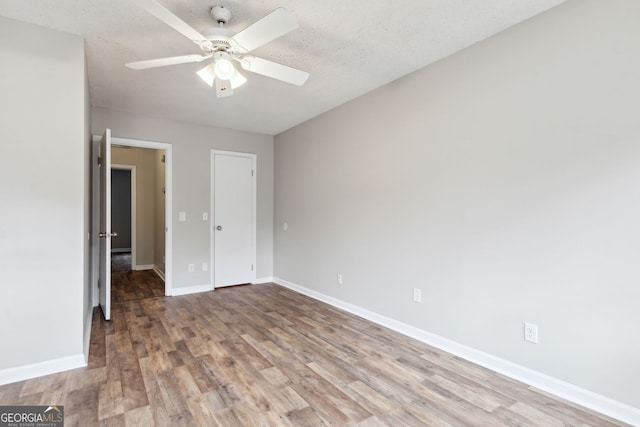 unfurnished bedroom featuring hardwood / wood-style floors, ceiling fan, and a textured ceiling