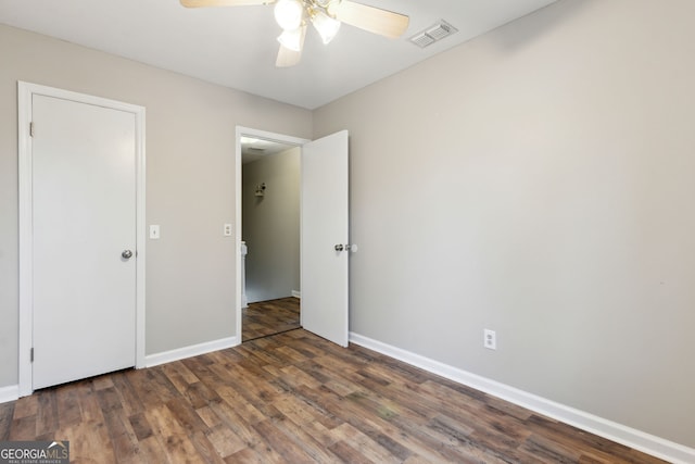 unfurnished bedroom with ceiling fan and dark hardwood / wood-style flooring