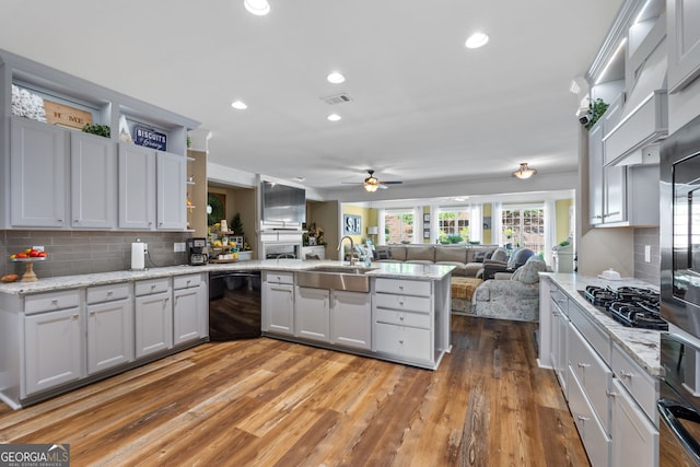 kitchen featuring black dishwasher, backsplash, light hardwood / wood-style floors, and sink