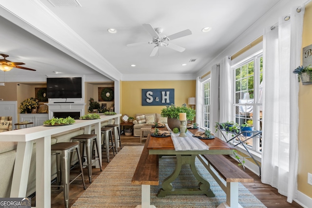 dining room with ceiling fan, dark hardwood / wood-style flooring, and ornamental molding