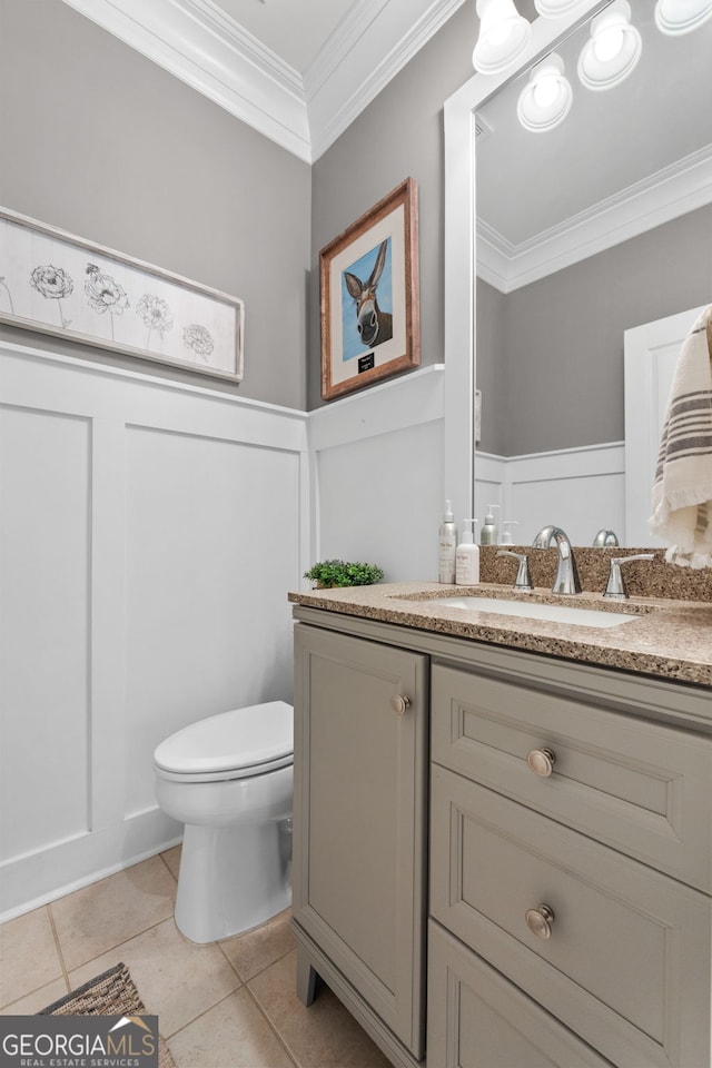 bathroom with tile patterned floors, toilet, vanity, and ornamental molding