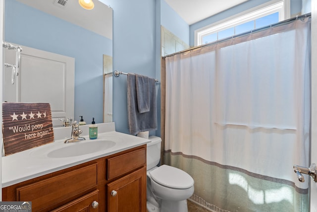 bathroom featuring walk in shower, vanity, and toilet