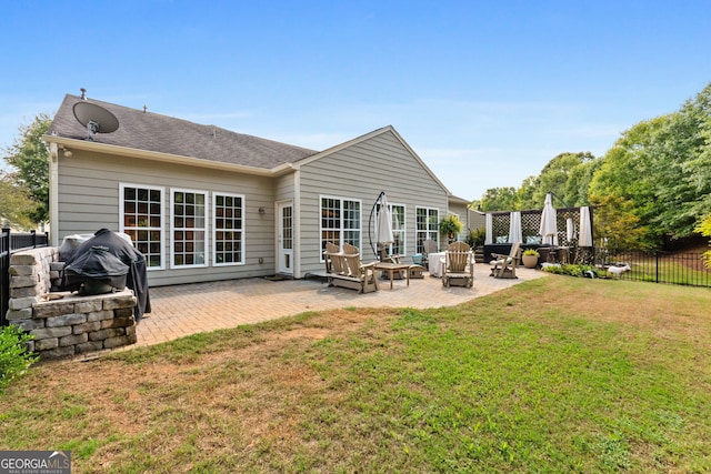 back of house featuring a lawn and a patio area