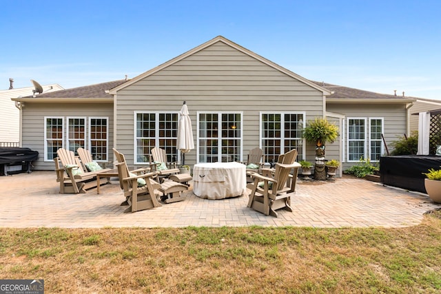 rear view of house with a lawn and a patio