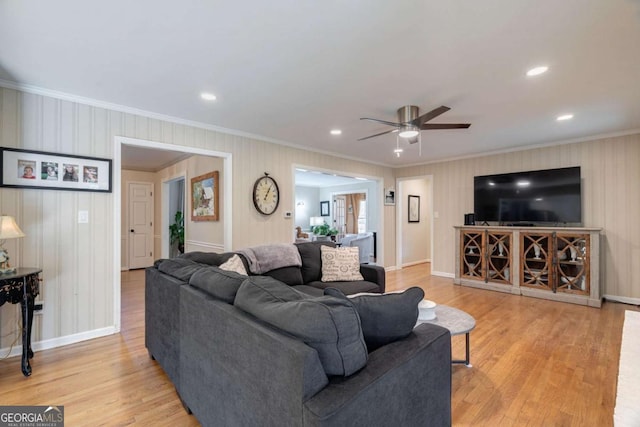 living room featuring ceiling fan, light hardwood / wood-style flooring, and ornamental molding