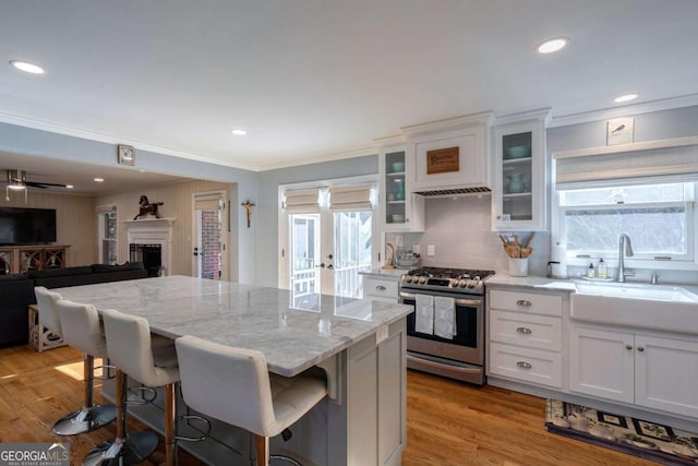 kitchen with white cabinets, a breakfast bar, gas stove, and a kitchen island