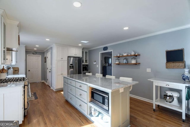 kitchen with white cabinetry, a center island, dark hardwood / wood-style flooring, crown molding, and appliances with stainless steel finishes