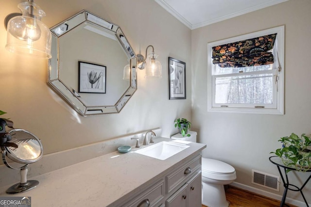 bathroom featuring crown molding, hardwood / wood-style floors, vanity, and toilet