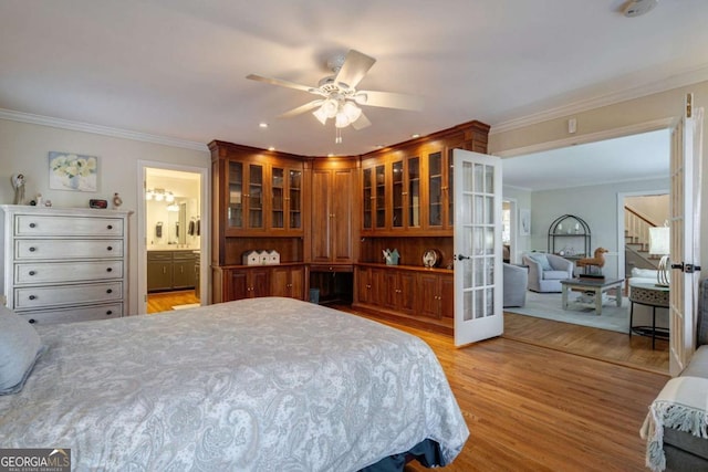 bedroom with ceiling fan, ensuite bathroom, light hardwood / wood-style floors, and ornamental molding