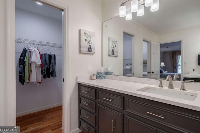 bathroom with hardwood / wood-style floors, vanity, and crown molding