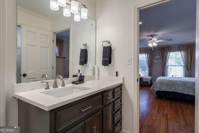 bathroom with ceiling fan, vanity, wood-type flooring, and ornamental molding