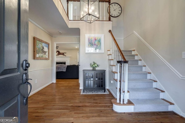 foyer featuring crown molding, hardwood / wood-style floors, and a chandelier