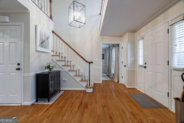 foyer featuring wood-type flooring and ornamental molding