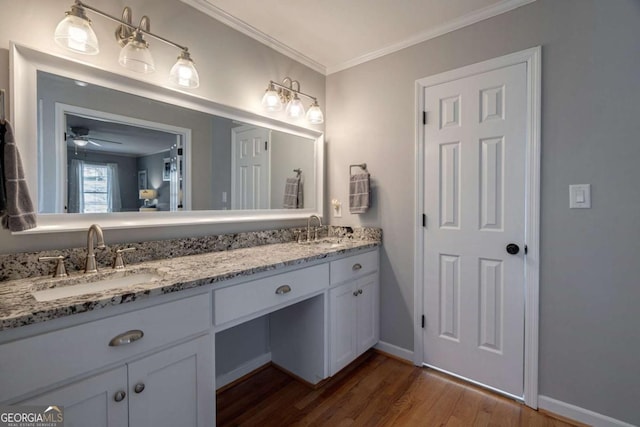 bathroom featuring ceiling fan, crown molding, vanity, and hardwood / wood-style floors