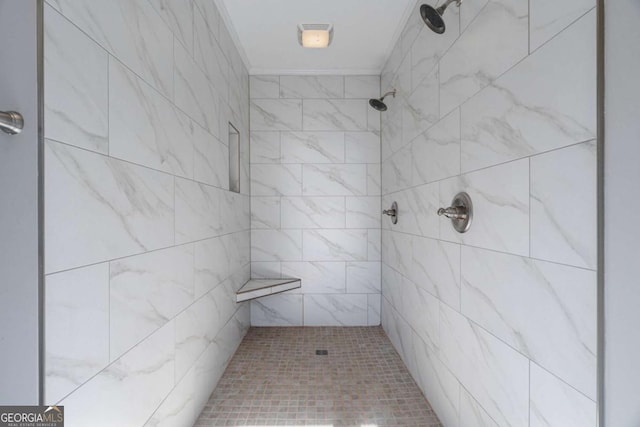 bathroom with tiled shower and crown molding