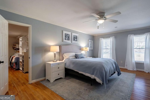 bedroom with a closet, a spacious closet, ceiling fan, and light hardwood / wood-style floors