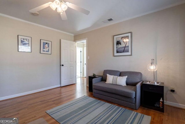 living room with ceiling fan, wood-type flooring, and crown molding