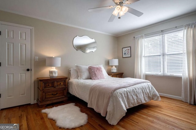 bedroom featuring light wood-type flooring, ceiling fan, and crown molding